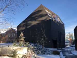 Arctic Museum building image with inuksuk sculptuer in front.